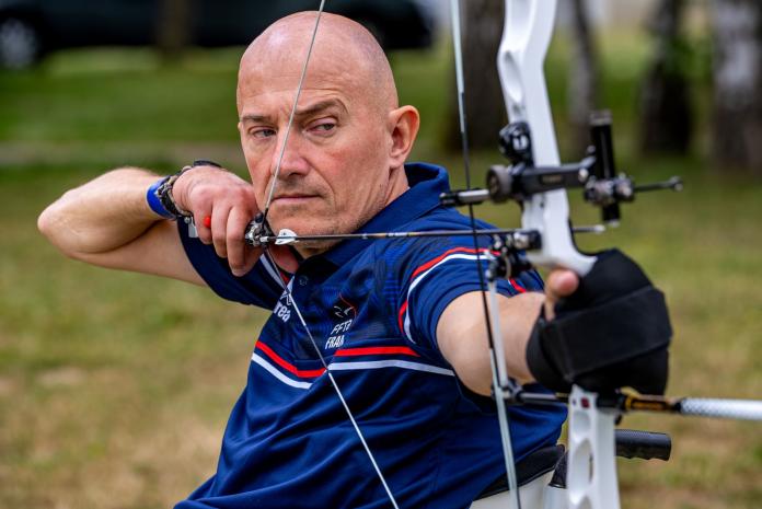 French Para archer Damien Letulle is preparing to shoot an arrow during competition. 